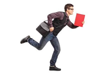 Full length portrait of a student in rush running with notebook isolated on white backgroundの写真素材