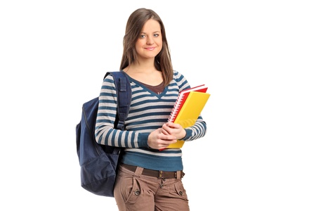 Smiling school girl posing with her books isolated on white backgroundの写真素材