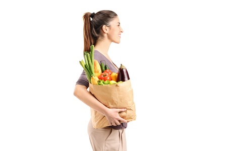 A female holding a paper bag with groceries isolated against white backgroundの写真素材