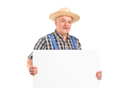 A mature smiling farmer holding a banner isolated on white backgroundの写真素材