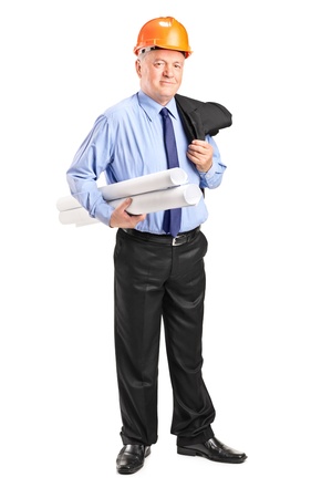 Full length portrait of a mature construction worker with helmet holding blueprints isolated on white backgroundの写真素材