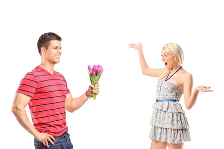 A boyfriend giving a bunch of flowers to his excited woman isolated against white backgroundの写真素材