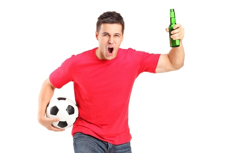 A portrait an euphoric fan holding a beer bottle and football cheering isolated on white backgroundの写真素材