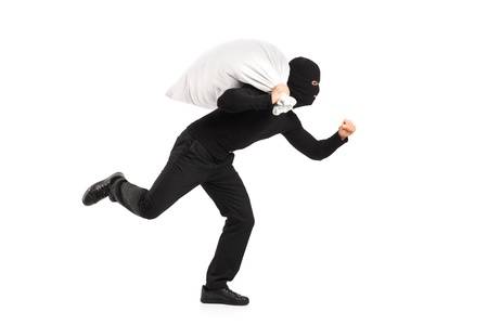 Thief carrying a bag and running away isolated on white backgroundの写真素材
