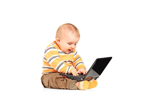 A studio shot of baby boy working on a laptop isolated on white backgroundの写真素材
