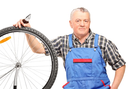 Middle aged male holding pliers and repairing bicycle wheel isolated on white backgroundの写真素材