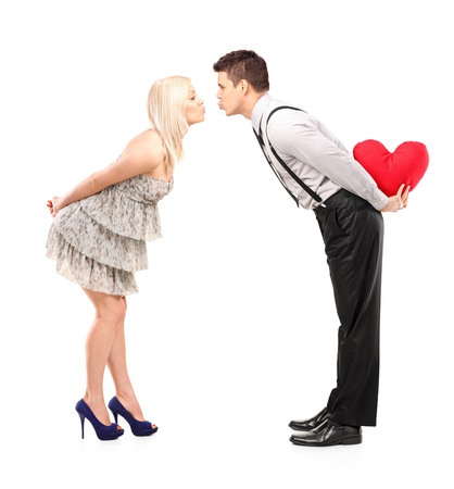 Full length portrait of boyfriend and girlfriend giving kisses isolated on white backgroundの写真素材