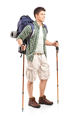Full length portrait of hiker with backpack holding hiking poles and posing isolated on white backgroundの写真素材