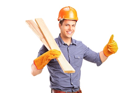A smiling manual carpenter holding sills and giving thumb up isolated on white background