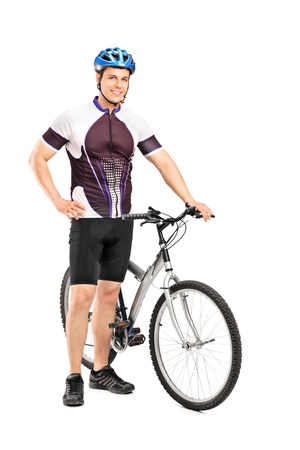 Full length portrait of a young bicyclist posing next to a bicycle isolated on white backgroundの写真素材