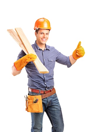 A smiling female carpenter holding sills and giving thumb up isolated on white backgroundの写真素材