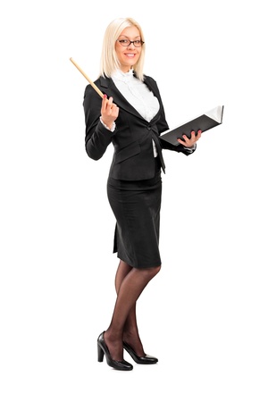 Full length portrait of a female teacher posing with a book in her hand isolated on white backgroundの写真素材