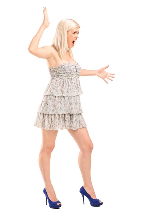 Full length portrait of a nervous blond female shouting isolated on white backgroundの写真素材