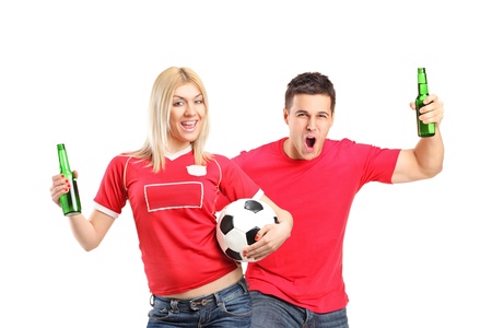 Male and female euphoric fans holding beer bottles and football cheering isolated on white backgroundの写真素材