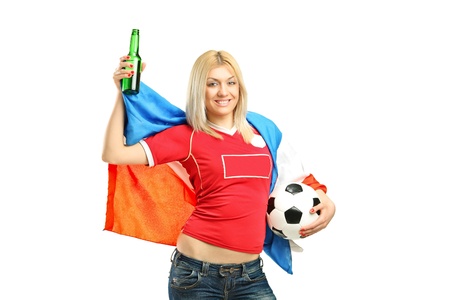 Full length portrait of a happy female fan holding a beer bottle and football isolated on white backgroundの写真素材
