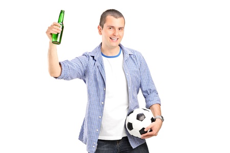An euphoric male fan holding a football and beer bottle isolated on white backgroundの写真素材
