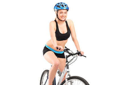 Smiling female biker with helmet sitting on a bike isolated against white backgroundの写真素材