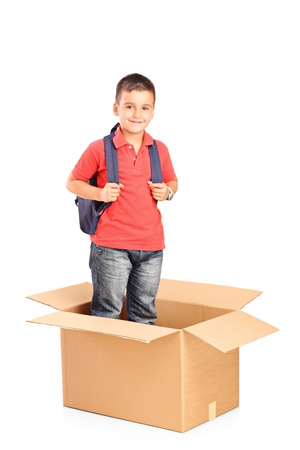 A child with backpack standing in a cardbox isolated on white backgroundの写真素材