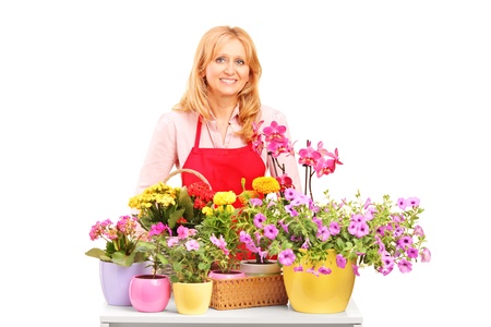 A mature female florist and flowers isolated on white backgroundの写真素材