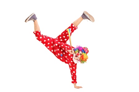 A playful clown with happy expression on face, holding a horn isolated on white backgroundの写真素材