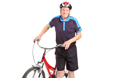 A senior bicyclist posing next to a bicycle isolated on white backgroundの写真素材