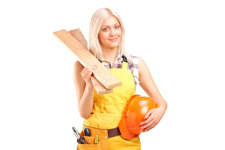 A smiling female carpenter holding sills and helmet isolated on white backgroundの写真素材