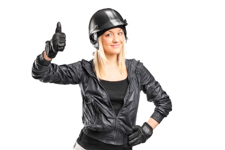 A smiling female motorcycler giving a thumb up isolated on white backgroundの写真素材
