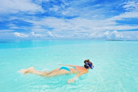 A woman in swimsuit snorkeling in Kuredu resort, Maldives islandの写真素材