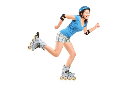 Full length portrait a smiling girl on rollers skating isolated on white backgroundの写真素材
