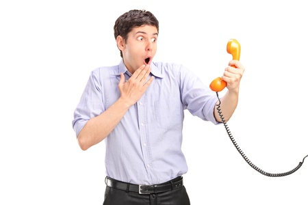 A shocked man holding a telephone tube isolated on white backgroundの写真素材
