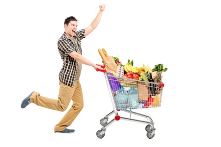 Full length portrait of a happy man pushing a shopping cart, isolated on white backgroundの写真素材