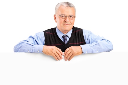 Mature man posing behing white panel, isolated on white backgroundの写真素材