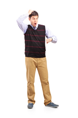 Full length portrait of a man looking at his watch, isolated on white backgroundの写真素材