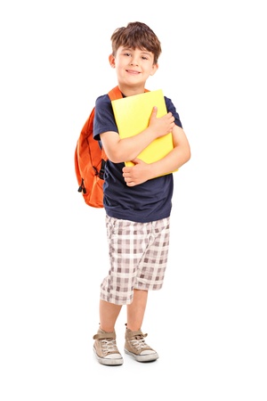 Full length portrait of a school boy with backpack holding a notebook isolated on white backgroundの写真素材