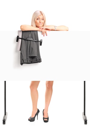 Full length portrait of a blond woman dressing up behind panel isolated on white backgroundの写真素材