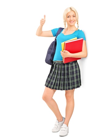 Full length portrait of a female student giving a thumb up, isolated on white backgroundの写真素材