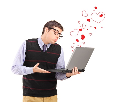 Young man giving a kiss on a laptop computer and red heart shapes around isolated on white backgroundの写真素材