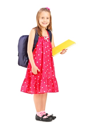 Full length portrait of a school girl holding notebook, isolated on white backgroundの写真素材
