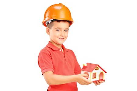 A child with helmet holding a model of house isolated on white backgroundの写真素材