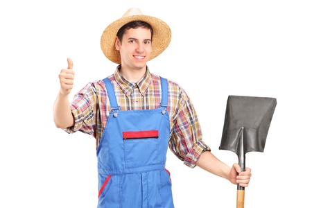 A male agricultural worker holding a shovel and giving a thumb up isolated on white backgroundの写真素材