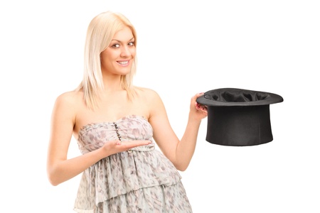 A smiling blond woman holding a top hat isolated on white backgroundの写真素材