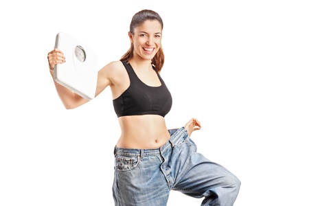 A weightloss woman holding a weight scale isolated on white backgroundの写真素材