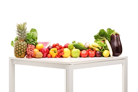 Fresh fruits and vegetables on a table isolated on white backgroundの写真素材