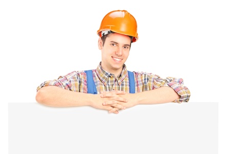 Satisfied male construction worker standing behind white panelの写真素材