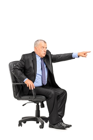 Angry boss sitting in armchair and pointing his finger isolated on white backgroundの写真素材
