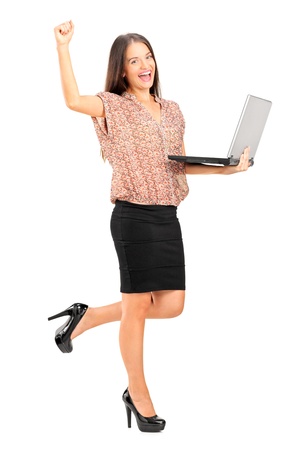 Full length portrait of a happy professional woman holding a laptop isolated on whiteの写真素材