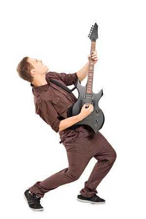 Full length portrait of a rock star playing guitar isolated on whiteの写真素材