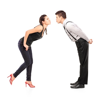 Full length portrait of a young heterosexual couple about to kiss isolated against white backgroundの写真素材