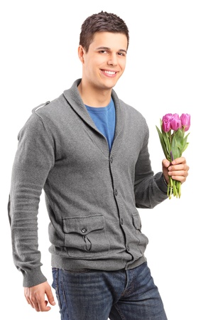 Handsome young man holding tulips isolated against white backgroundの写真素材
