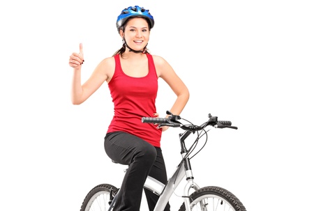 A bicyclist posing on a bicycle and giving a thumb up isolated against white backgroundの写真素材